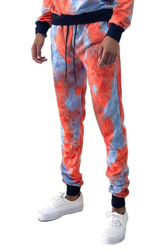 WEIV cotton tye dye sweatpants in orange and blue with black cuffs modeled with white sneakers