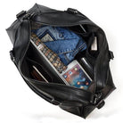 Cowskin leather travel bag with spacious interior holding clothing, gadgets, and travel essentials