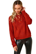 Women in a cozy knit lace-up sweater in red with lace-up detailing and ribbed texture