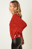 Side view of a cozy knit lace-up sweater in orange, perfect for stylish fall outfits