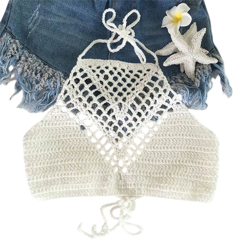 Crocheted bikini top on a white background with denim and flowers.