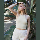Leto Accessories cropped fuzzy halter top in cream color styled with light shorts outdoors