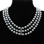 Elegant crown pendant statement jewelry necklace featuring three strands of silver pearls