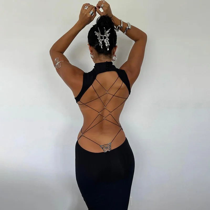 Woman wearing a black backless cut out club dress with crisscross straps and butterfly detail on back