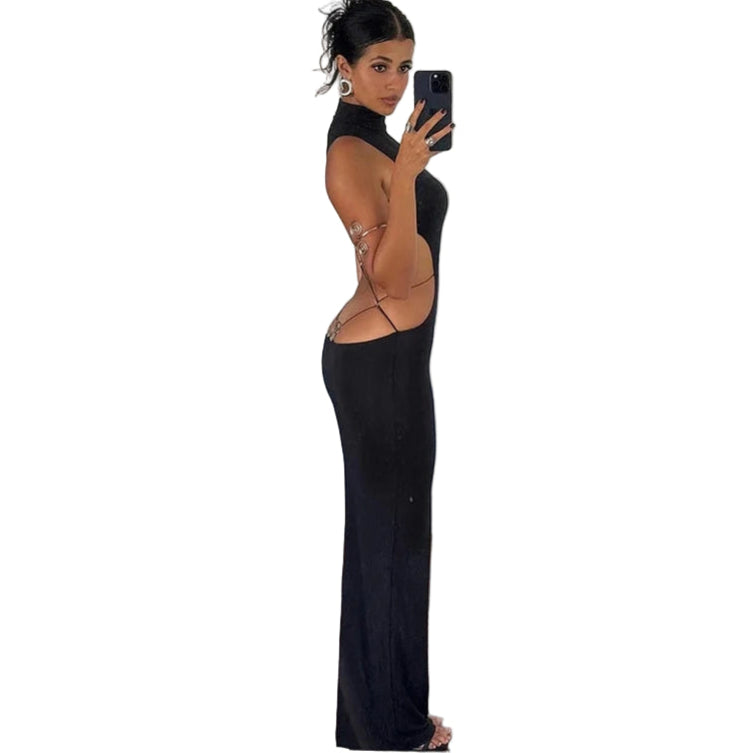 Woman wearing black backless cut out club dress taking a mirror selfie in a room with wooden floors
