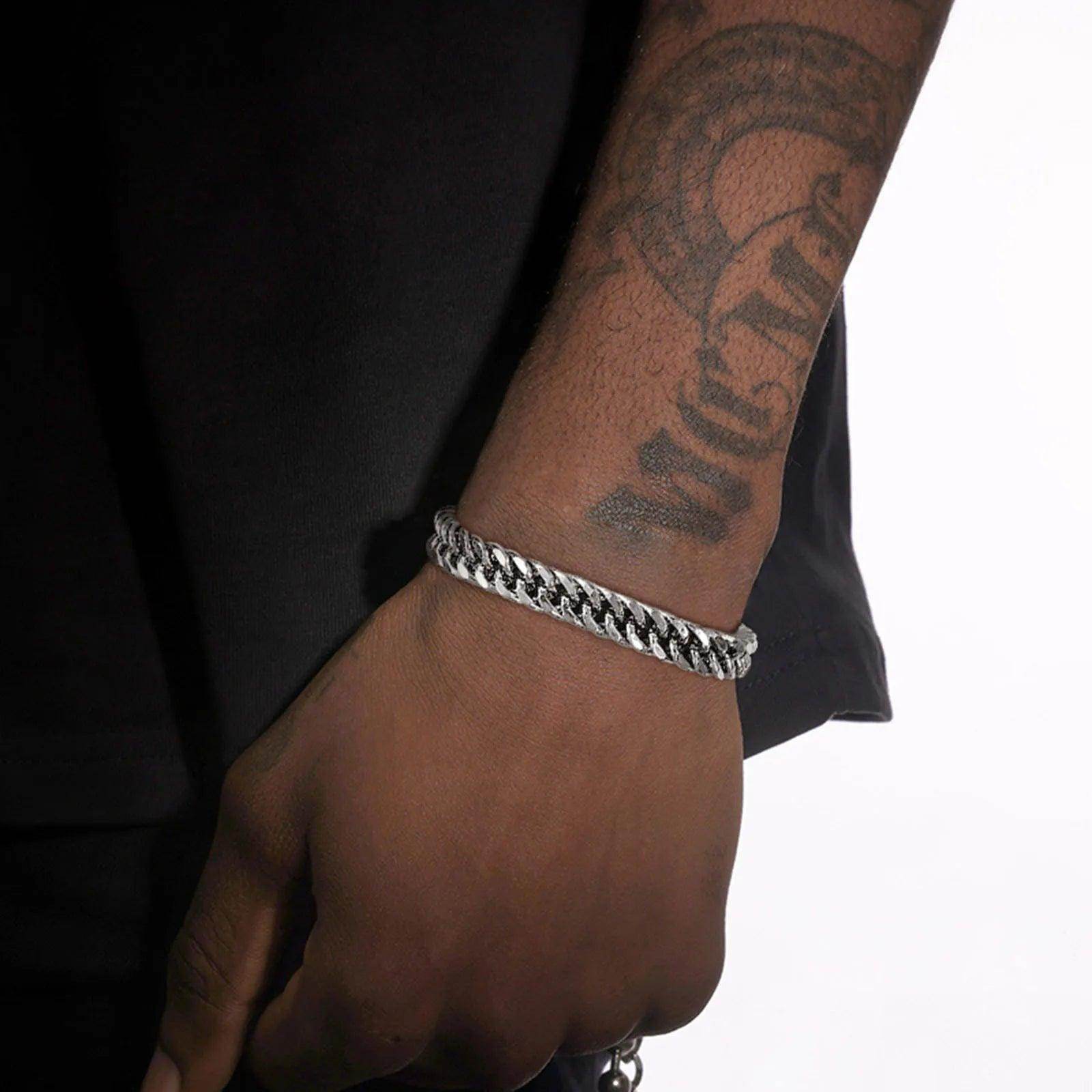 Stylish Cuban link bracelets for men worn on a tattooed wrist for a bold accessory look