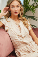 Cute summer ruffle romper with a buttoned neckline and feminine ruffled sleeves