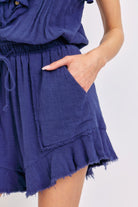 Cute summer ruffle romper in navy blue with stylish pockets and frayed hem for a playful look