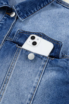 White smartphone in a blue denim pocket with visible buttons.