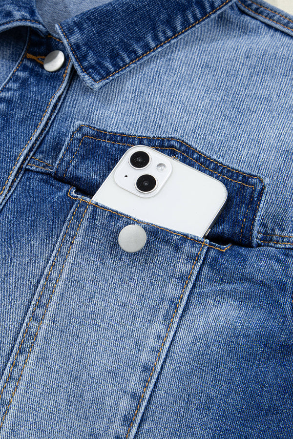 White smartphone in a blue denim pocket with visible buttons.