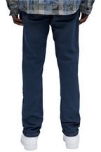 Dark wash urban jeans men by VacationGrabs shown from the back on a model wearing white sneakers