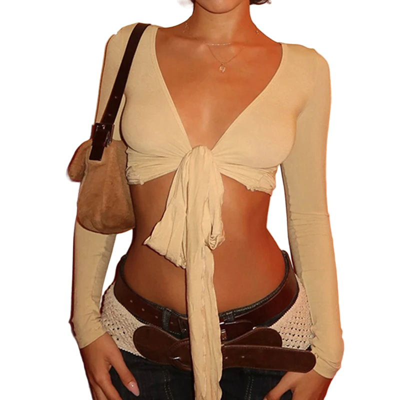 Beige womens cropped tie front top with long sleeves and deep V neckline styled with brown belt and handbag
