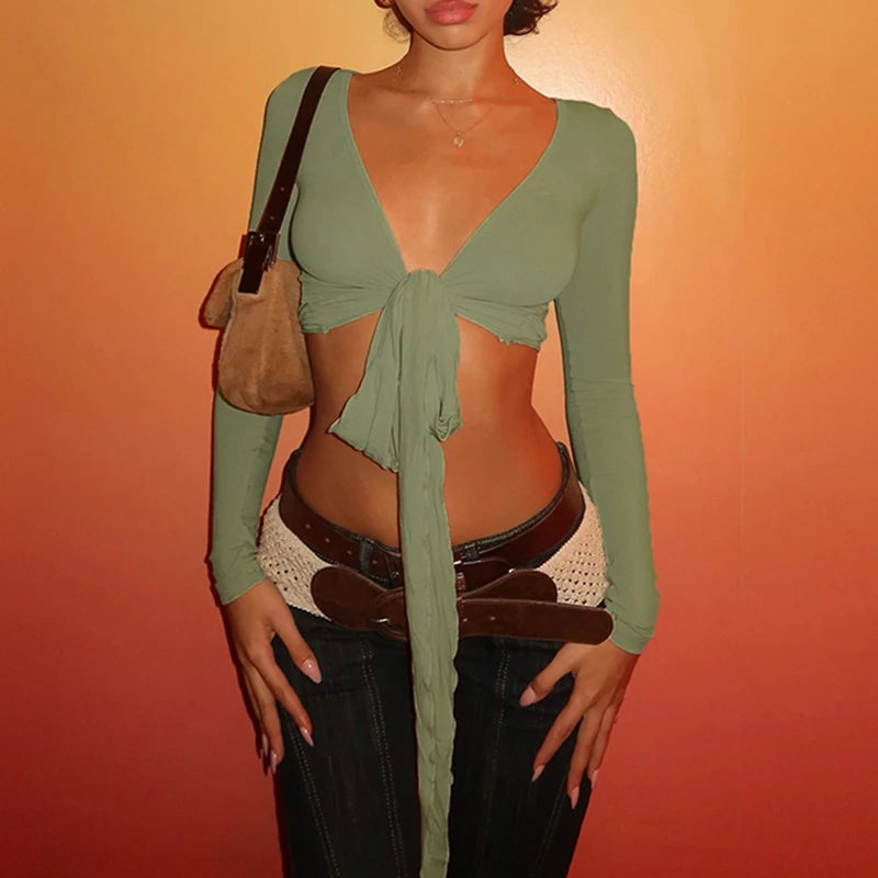 Womens cropped tie front top in sage green with long sleeves styled with dark jeans and layered belts