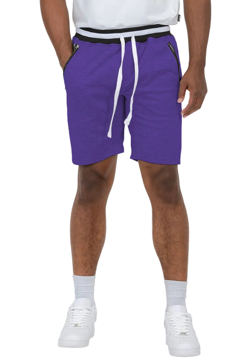 Person wearing purple shorts with a white drawstring on a plain background