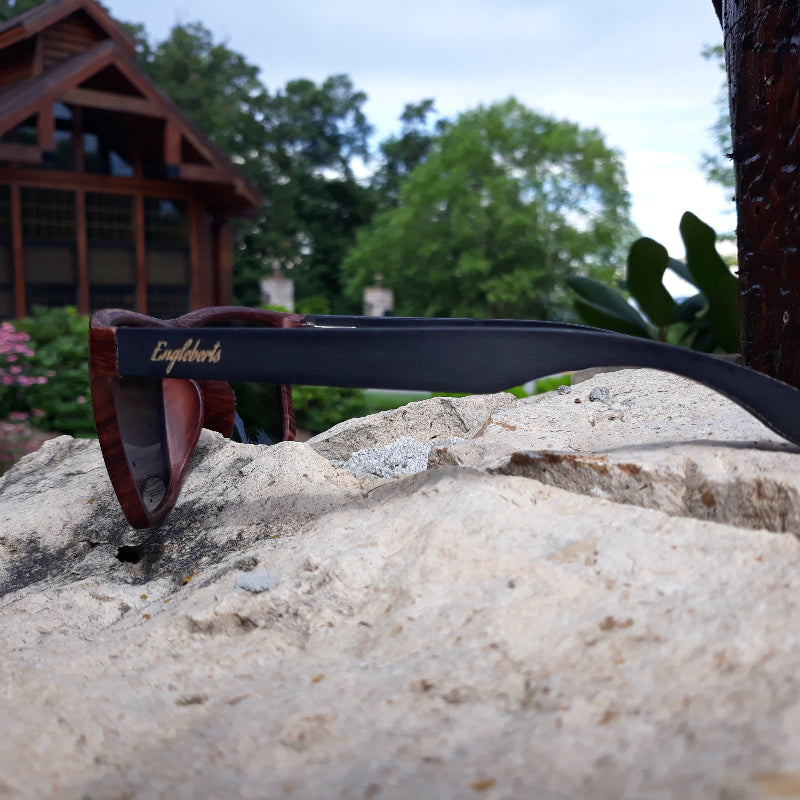 Sunglasses with a brand name on a rock outdoors