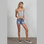 Denim Lab USA women's mid-rise distressed shorts in blue denim styled with a gray tank top and casual shoes