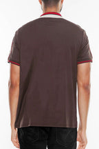 Back view of a man wearing a designer brown polo shirt by WEIV with red and beige collar details