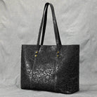 Stylish black designer shoulder bag for laptops with elegant embossed floral pattern and sturdy handles