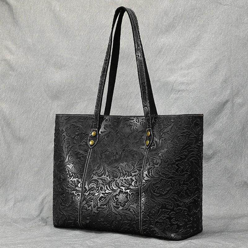 Black embossed designer shoulder bag for laptops with durable handles and stylish floral pattern