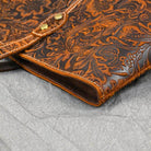 Stylish brown designer shoulder bag for laptops with intricate floral pattern and quality stitching