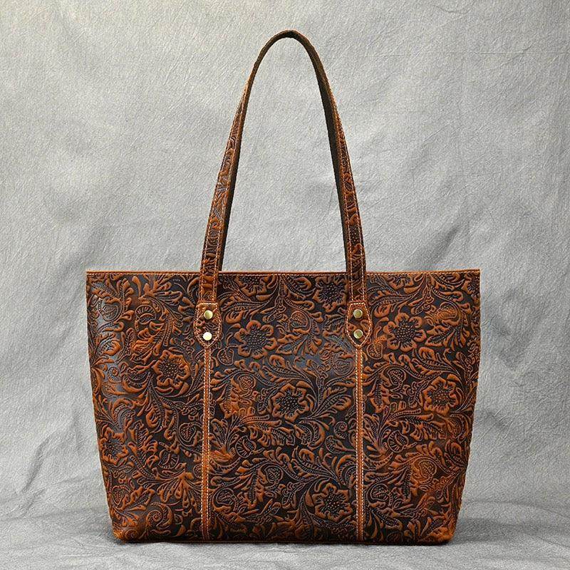 Stylish brown designer shoulder bag for laptops with intricate floral detailing and sturdy handles