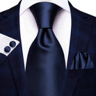 Stylish designer wedding ties for men in a classic navy color, paired with a sharp suit and pocket square.