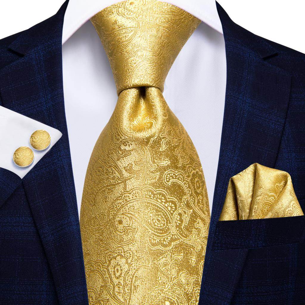 Elegant gold designer wedding ties for men featuring a paisley pattern, styled with a navy suit