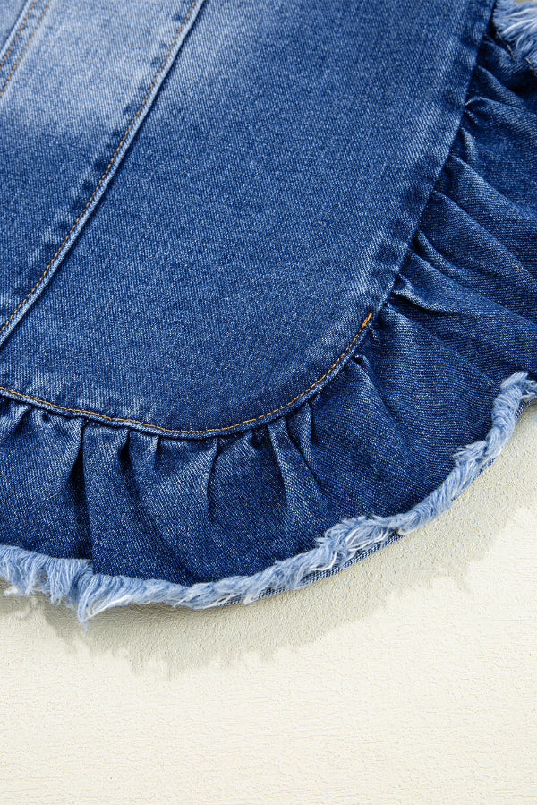 Close-up of a blue denim skirt with ruffled hem on a light background