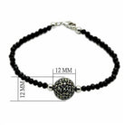 Elegant brass bracelet for vacation outfits featuring black beads and a sparkling focal bead