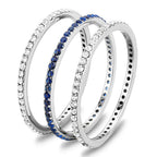 Set of three Women's Rings including an eternity band with blue stones and sparkling white stones