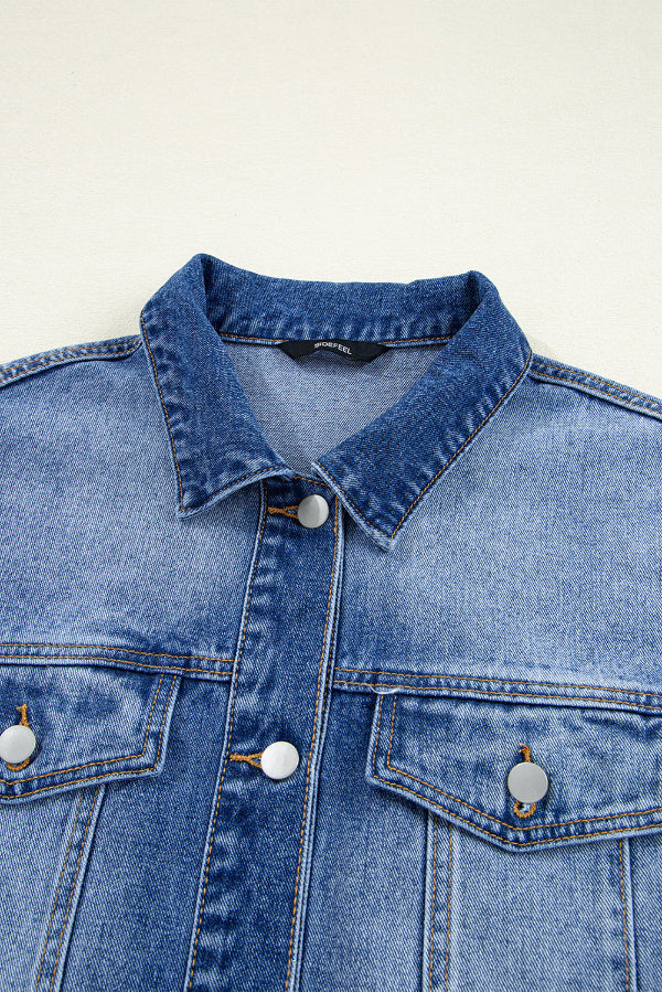 Close-up of a blue denim jacket with white buttons on a light gray background