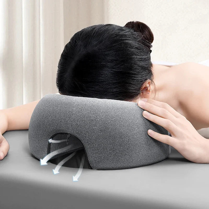 Gray face down pillow for massage, providing comfort during treatments