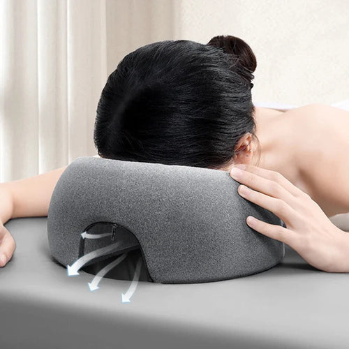 Gray face down pillow for massage, providing comfort during treatments