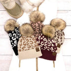 Collection of fashionable animal print beanie hats with faux fur pom poms from Aili's Corner