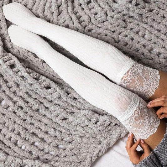 Aili's Corner fashionable knee high socks in white with lace trim, styled on a cozy grey blanket