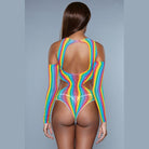 Back view of model wearing BE WICKED rainbow cutout bodysuit with open back high cut thong and long sleeves