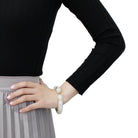 Stylish flash gold brass bracelet for women worn elegantly with a black top and skirt