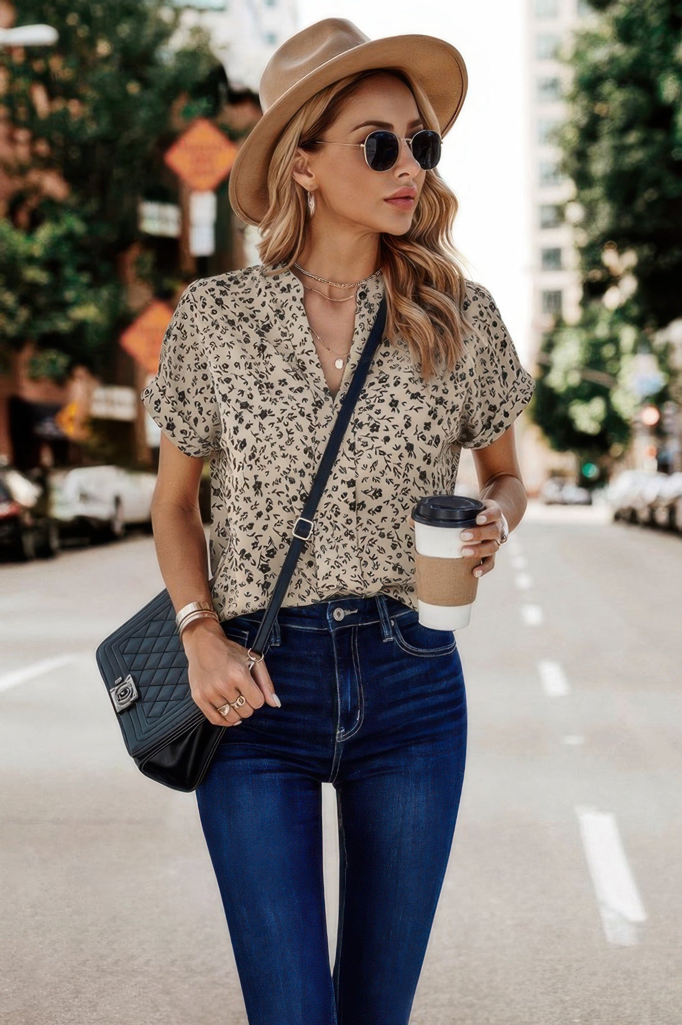 Stylish floral print v neck blouse paired with high-waisted jeans and a hat for a trendy look
