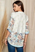 Women's floral roll up sleeve top in white with colorful floral patterns and a relaxed fit