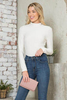 Andante USA Women's form-fitting travel bodysuit in white, styled with high-waisted jeans