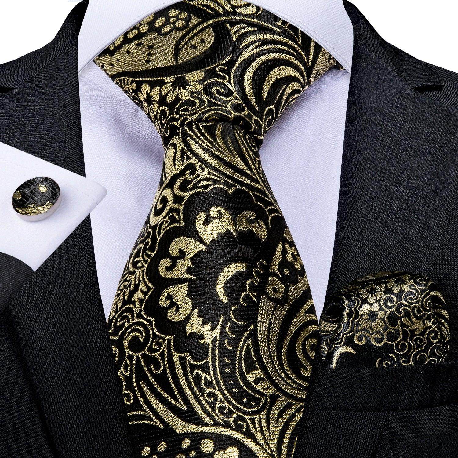 Elegant formal neck tie for men in black and gold paisley design, paired with matching pocket square