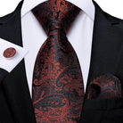 Elegant formal neck tie for men in black and red paisley pattern, paired with matching pocket square and cufflinks