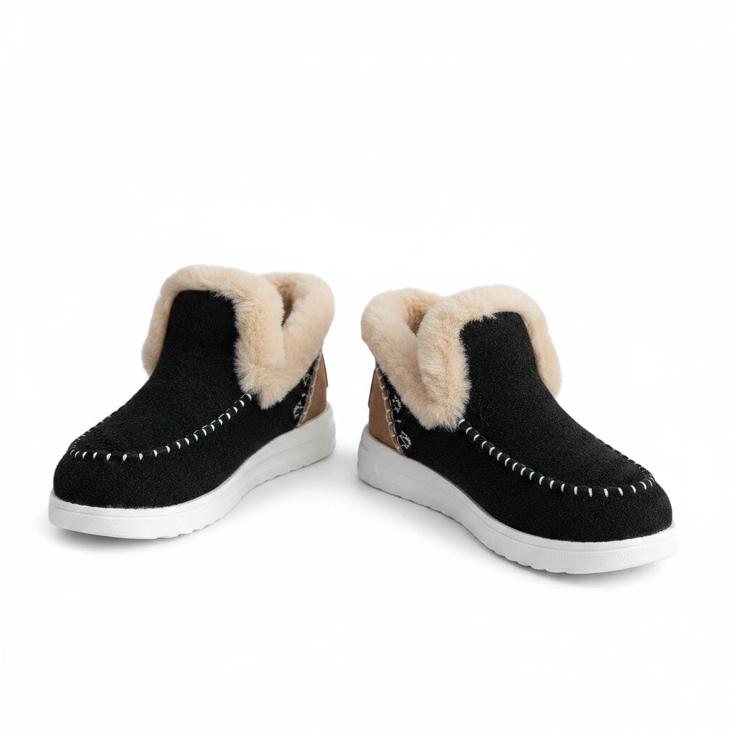Black slip-on shoes with fur trim worn with blue jeans on a white background