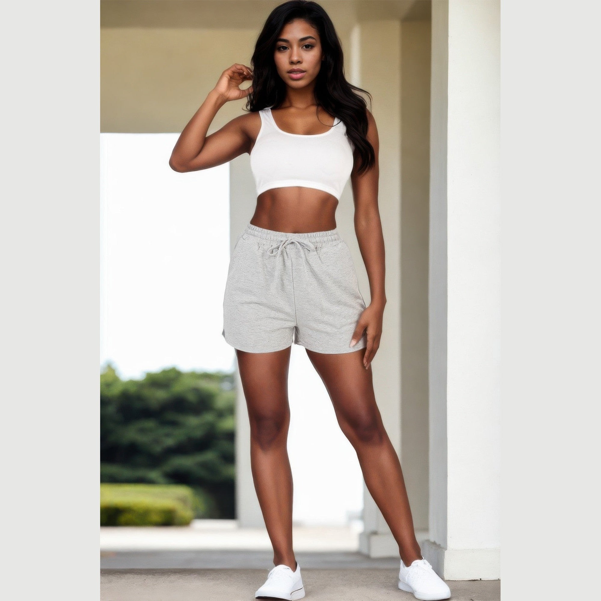 Woman wearing grey french terry shorts for women with drawstring waist and white crop top