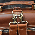 Close-up of a genuine leather backpack for travel featuring sturdy metal clasps and detailed stitching