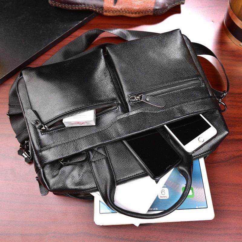 Genuine leather briefcase with multiple pockets and devices on a wooden desk