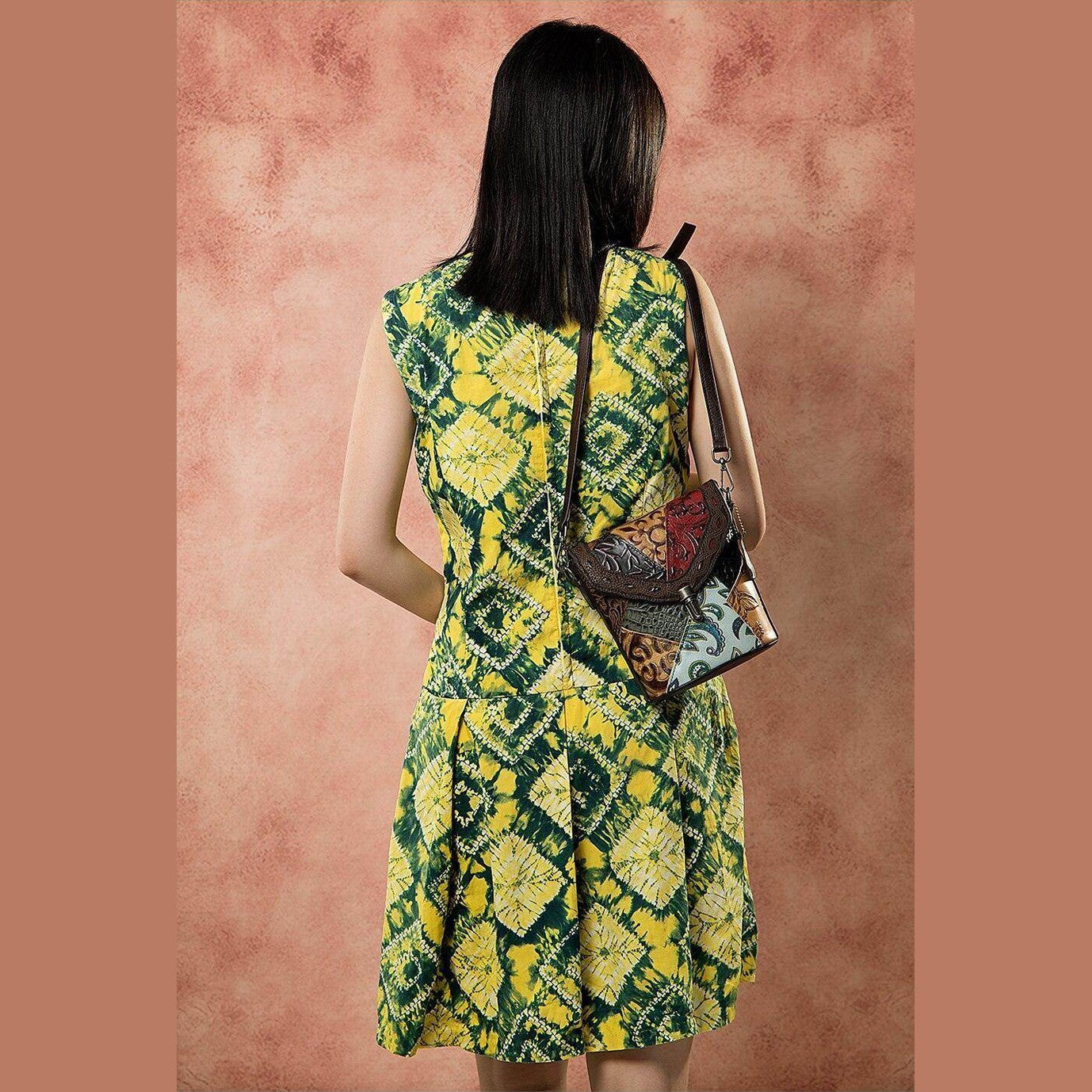 Stylish genuine leather hobo handbag worn crossbody with vibrant yellow dress for a casual look