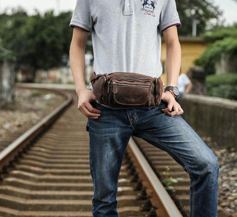 Man wearing a genuine leather waist bag while standing on railway tracks