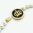 Gold crown pendant necklace for women with a pearl chain and elegant design