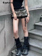 Woman wearing a gothic punk camouflage skirt paired with black lace shorts and black high boots